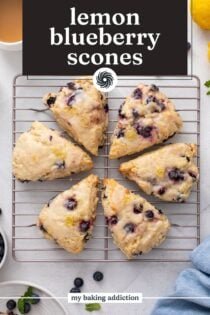 Overhead view of lemon blueberry scones arranged in a circle on a wire rack. Text overlay includes recipe name.