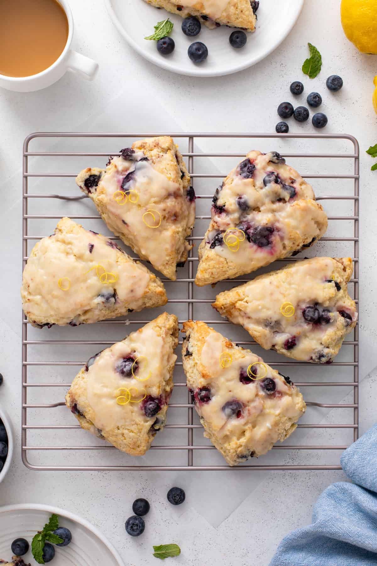 Overhead view of lemon blueberry scones arranged in a circle on a wire rack.