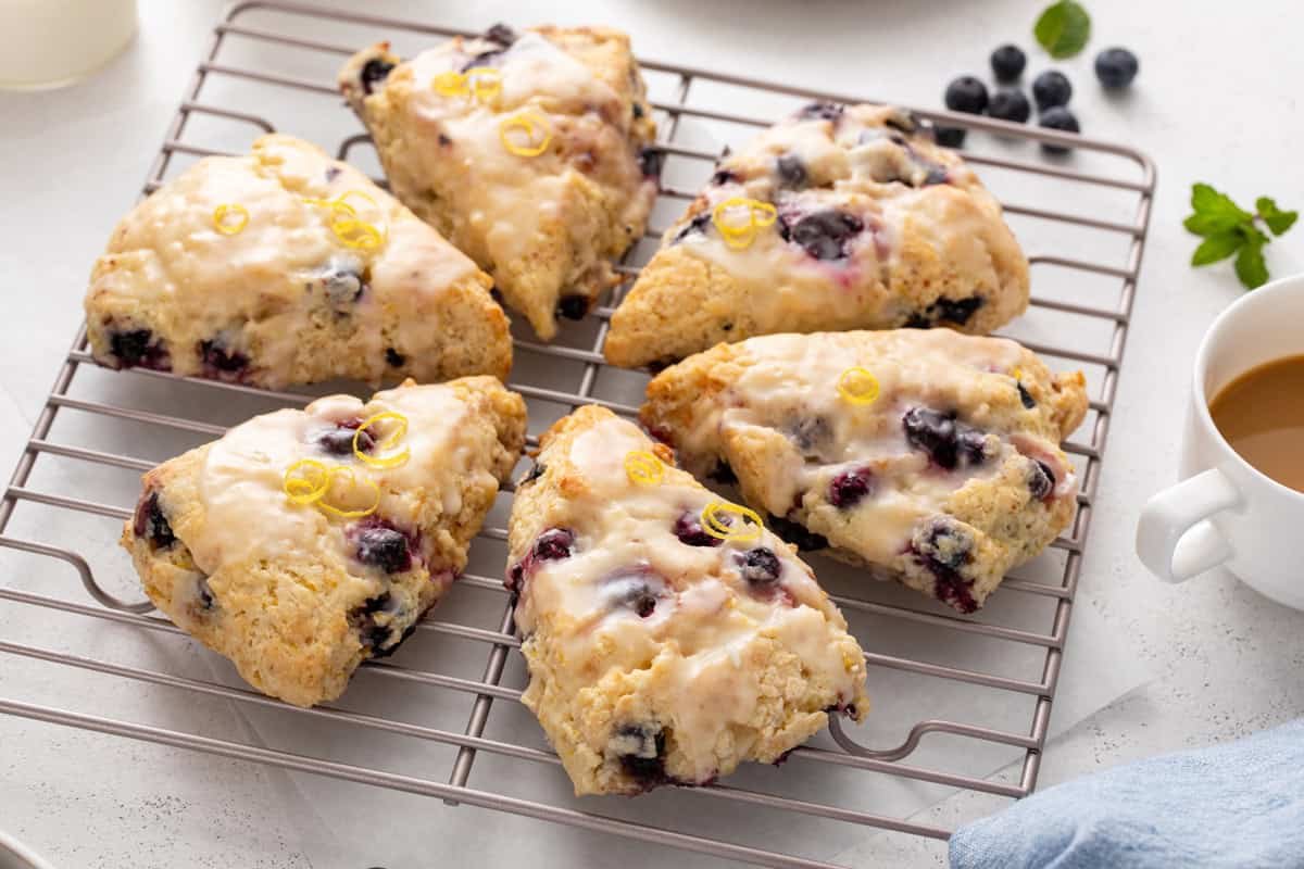 Lemon blueberry scones arranged in a circle on a wire rack.