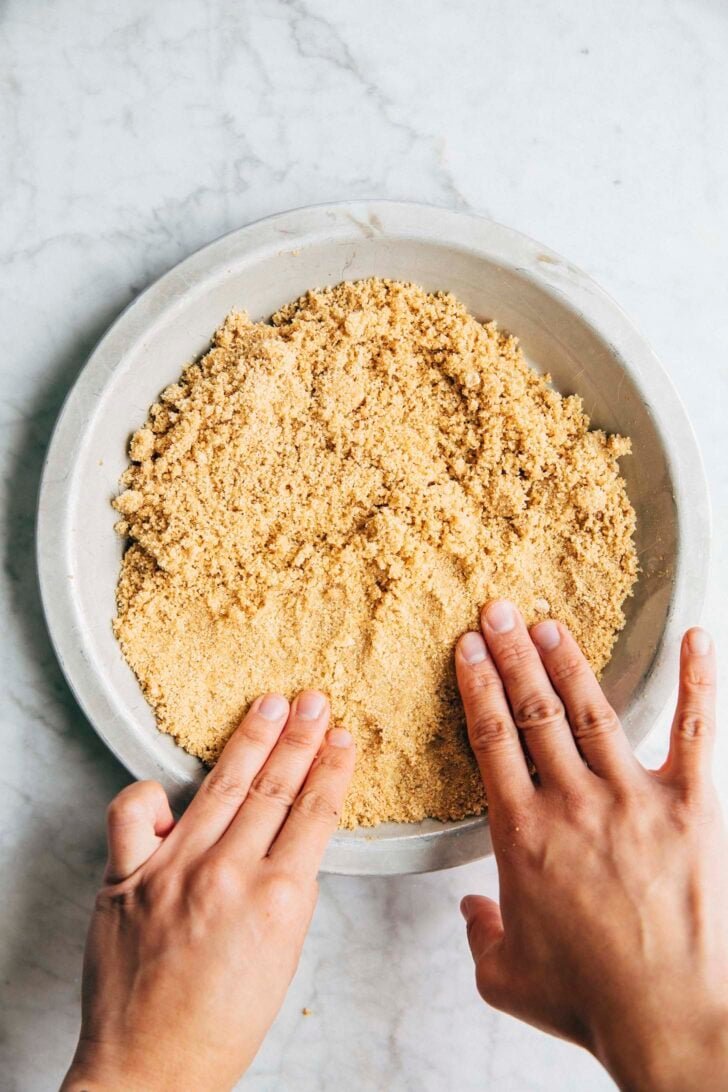 photo of Michelle from Hummingbird High pressing the crumbs into the pan to make the pie crust for Baja Blast pie