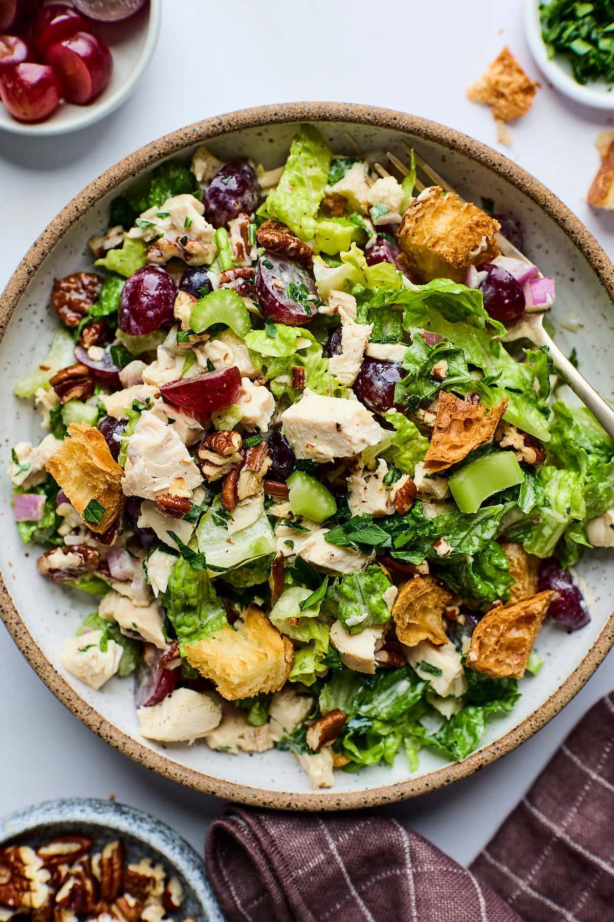 Chicken Salad with Grapes, Pecans & Croissant Croutons on plate with fork. 