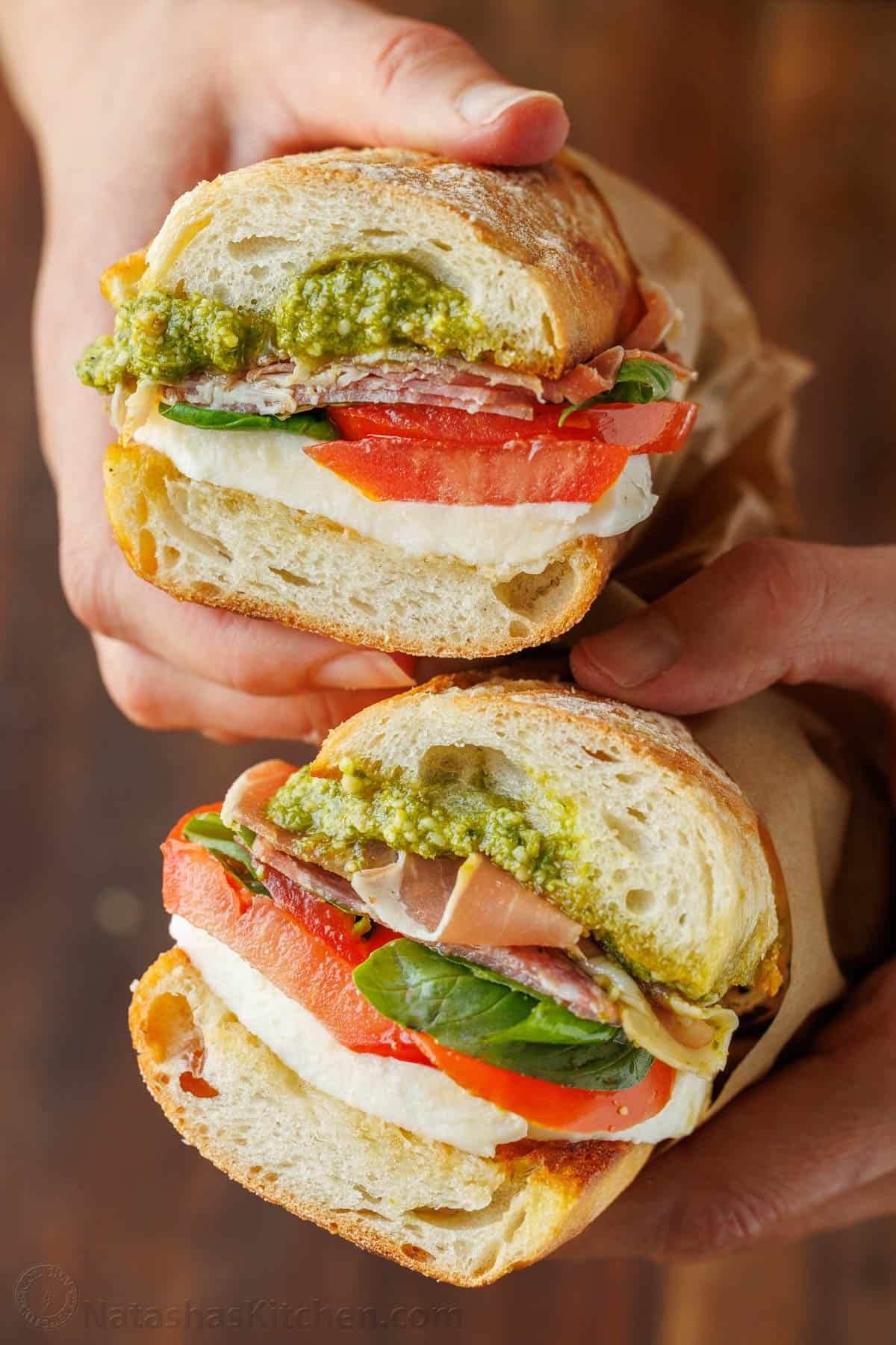 Italian sub sandwich cut in half with fresh tomato, pesto and mozzarella cheese