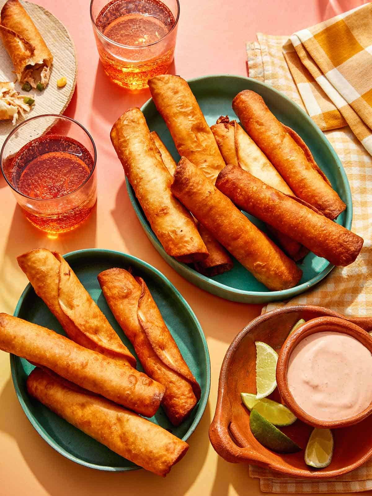 Flautas freshly made in some bowls with a dipping sauce on the side. 