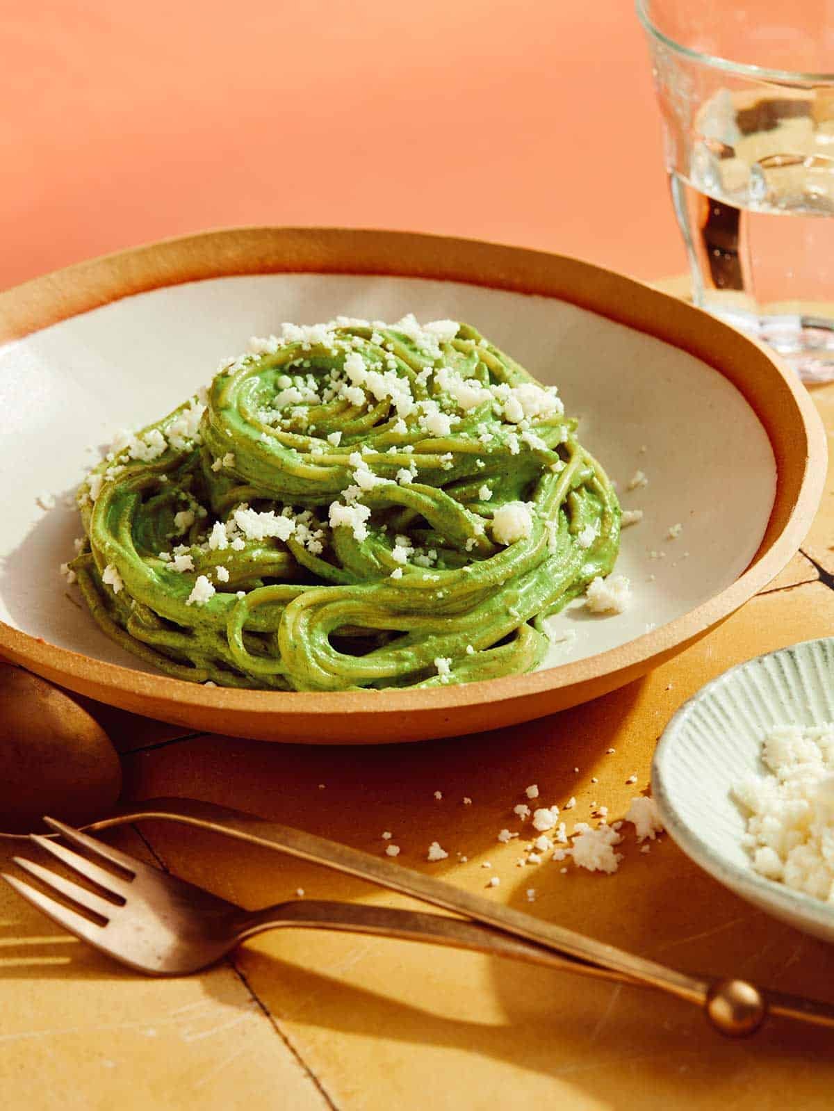 Tallarines Verde in a bowl with queso fresco on top. 
