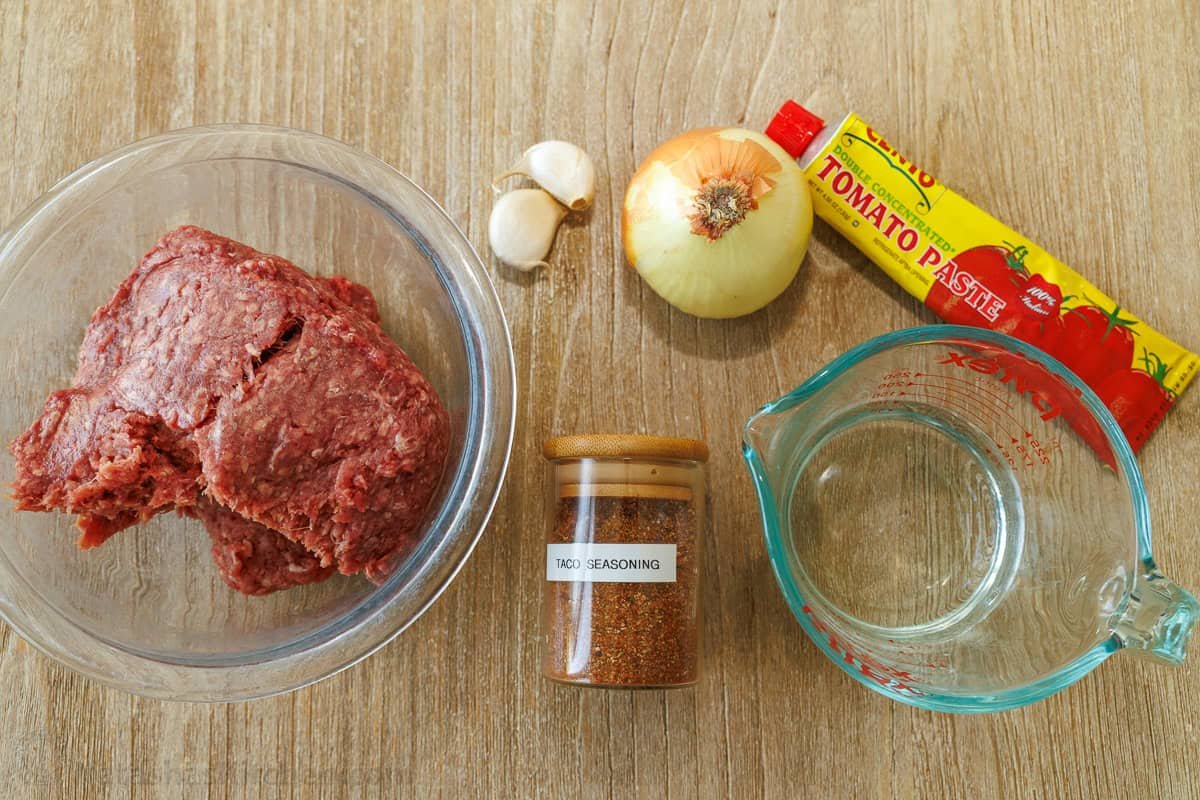 easy mexican dinner recipe with ground meat, garlic, onion, tomato paste, taco seasoning and water