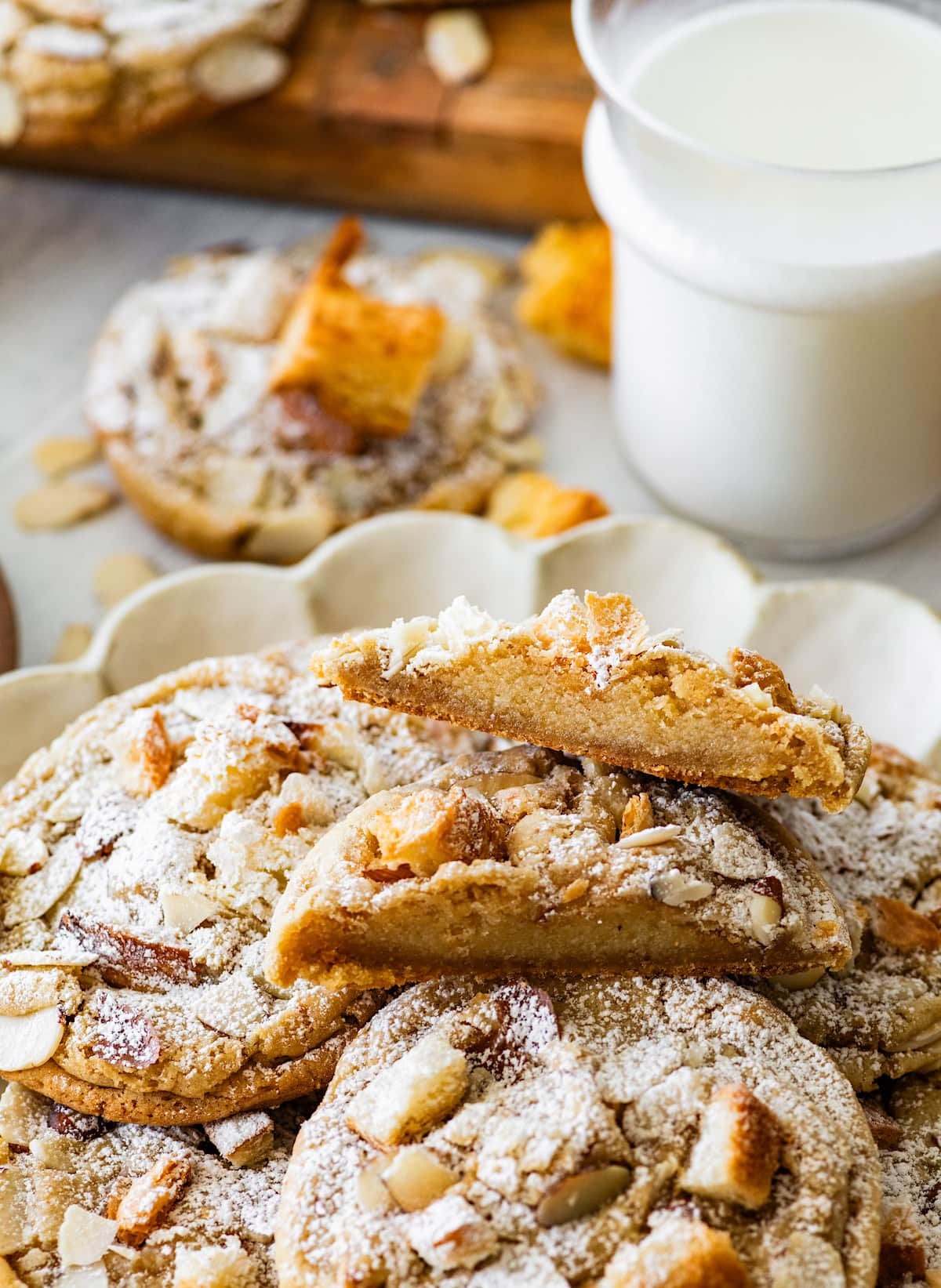 almond croissant cookies on plate with one broken half with almond filling. 