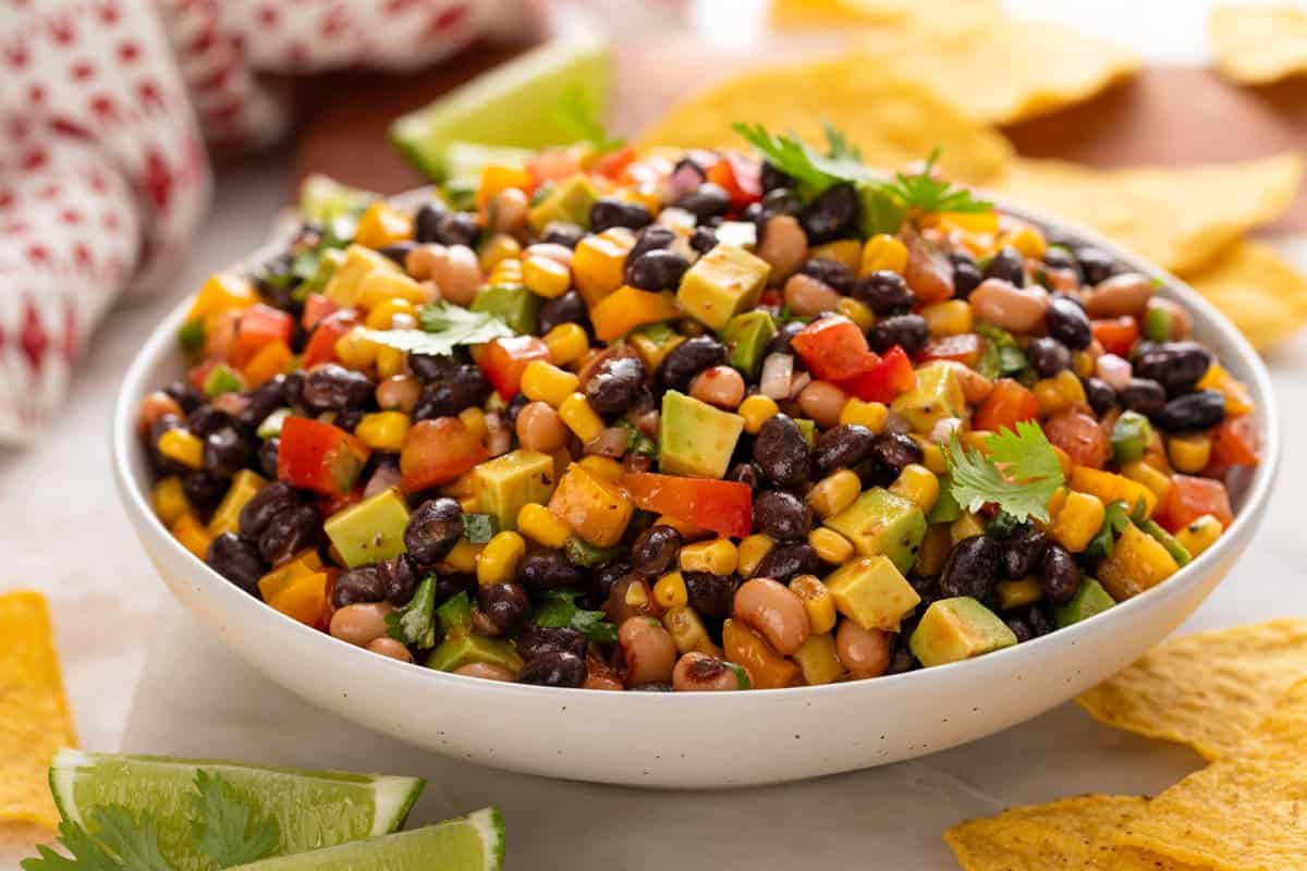 Side view of a large white serving bowl filled with cowboy caviar.