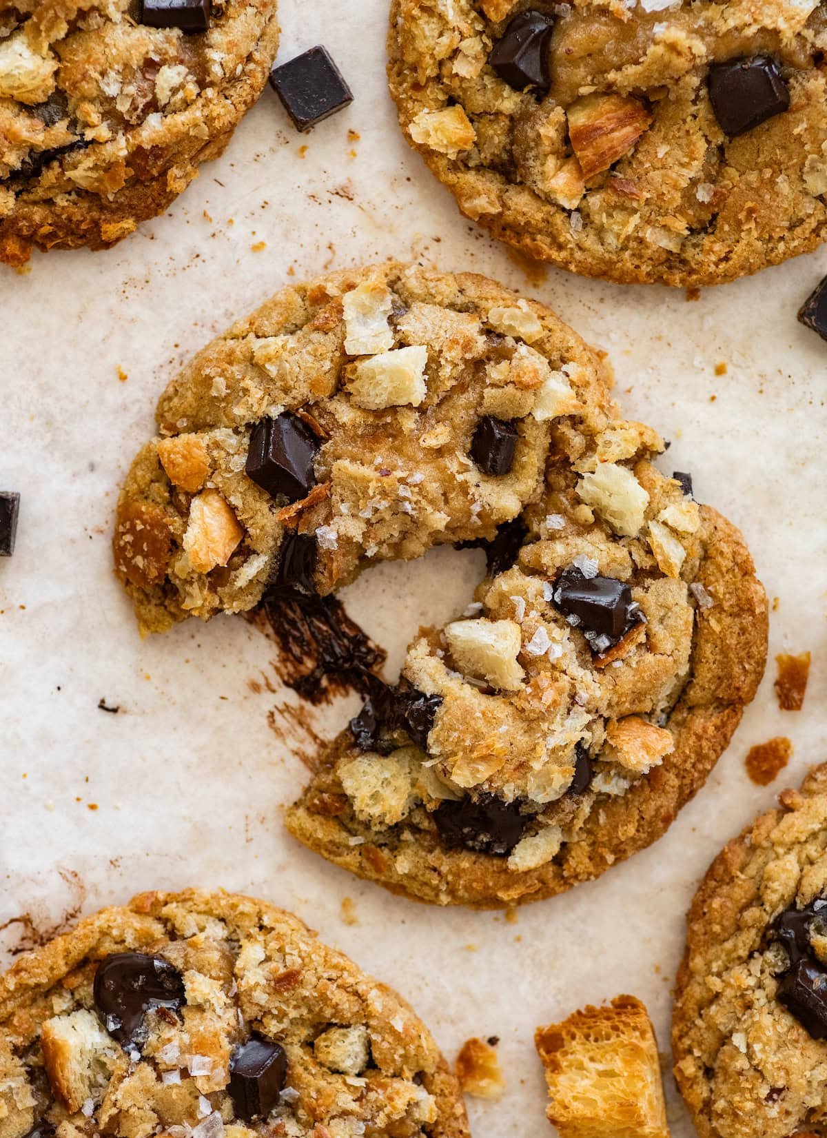 close up of chocolate croissant cookie with melty chocolate, croissant pieces, and flaky sea salt. 