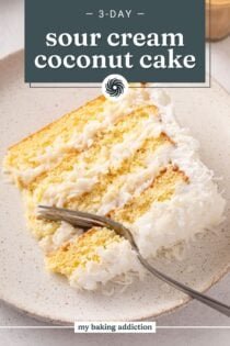 Fork cutting into a plated slice of sour cream coconut cake. Text overlay includes recipe name.