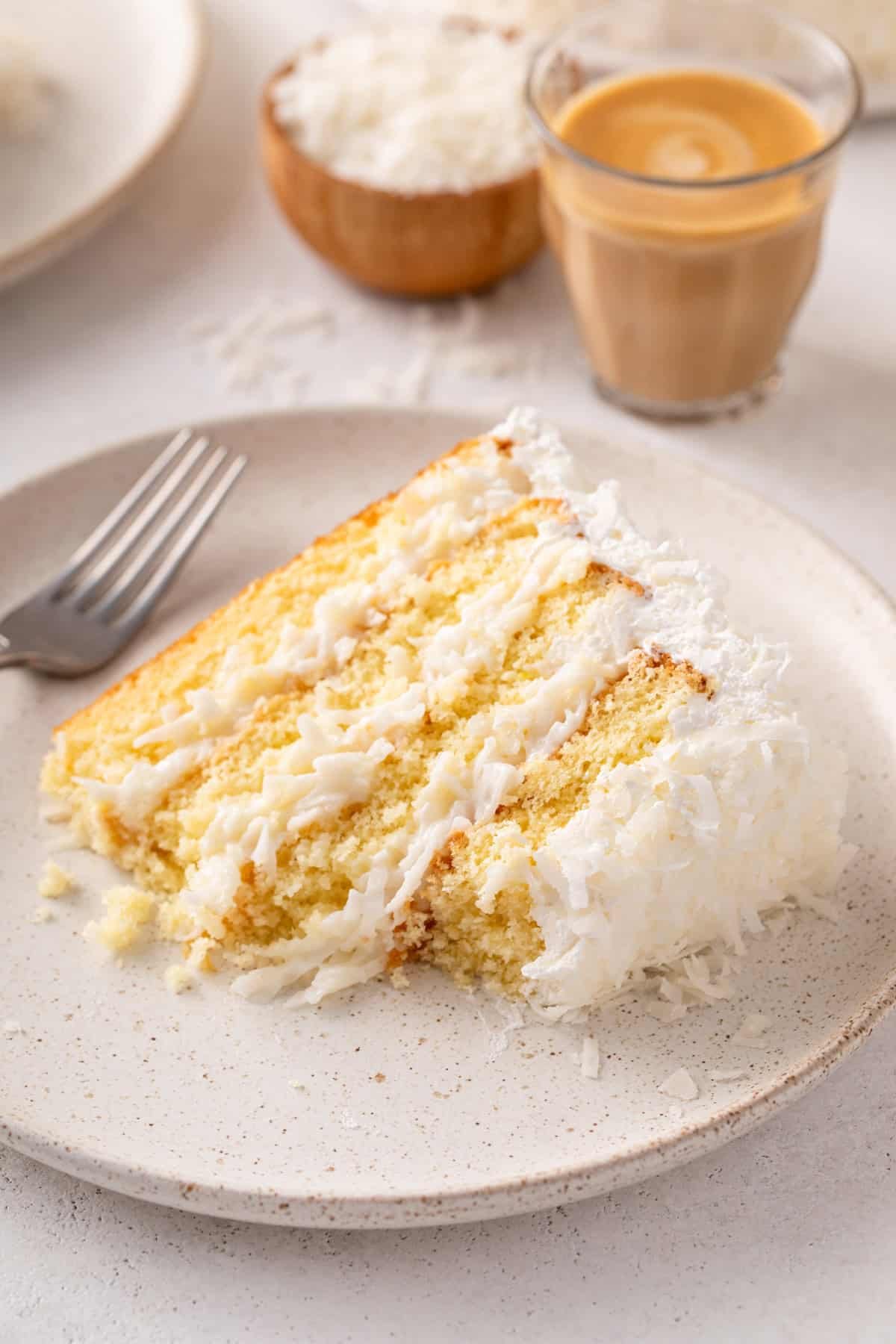 Plated slice of sour cream coconut cake on a plate.