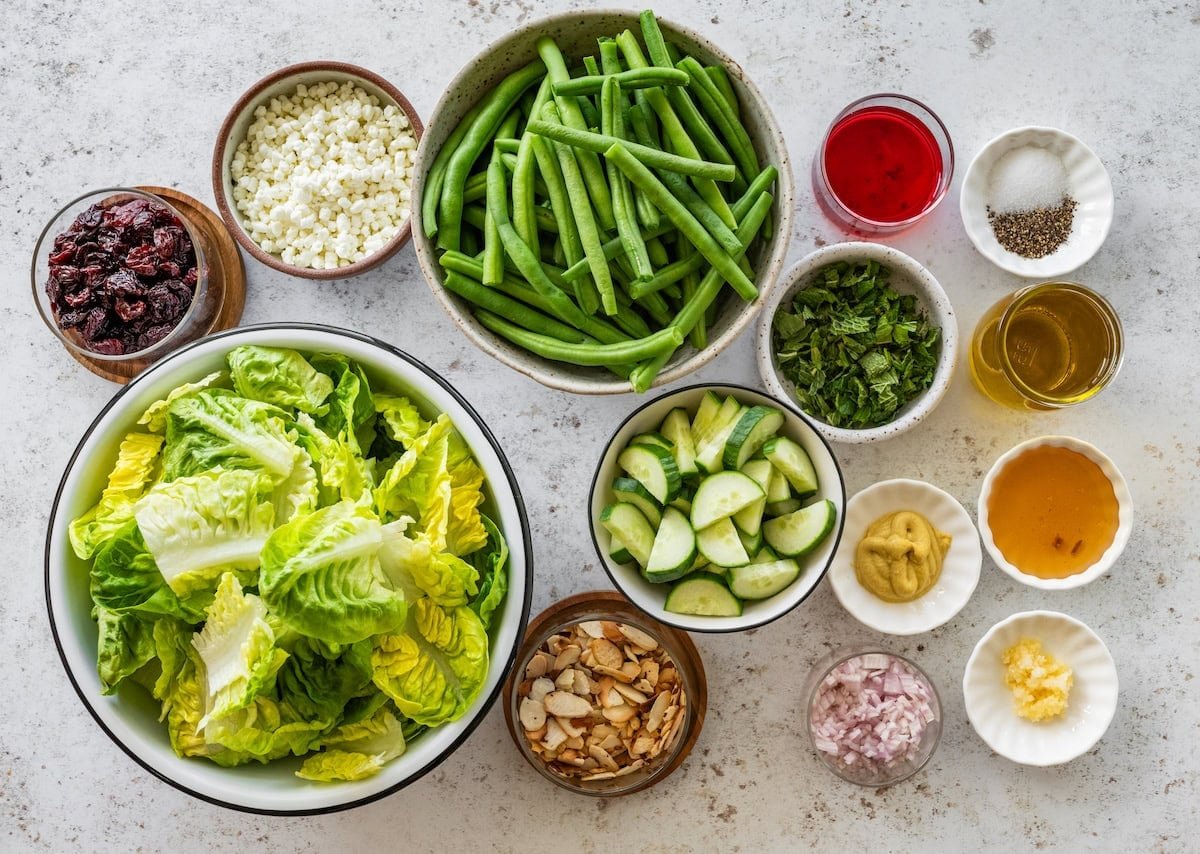 ingredients in bowls to make green bean salad with dried cherries and almonds. 