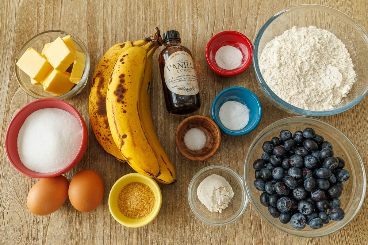 ingredients for the blueberry banana bread including butter, sugar, eggs, bananas, vanilla, salt, baking soda, baking powder, flour, and blueberries