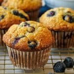 blueberry Banana Muffins on a cooling rack with white cupcake liners