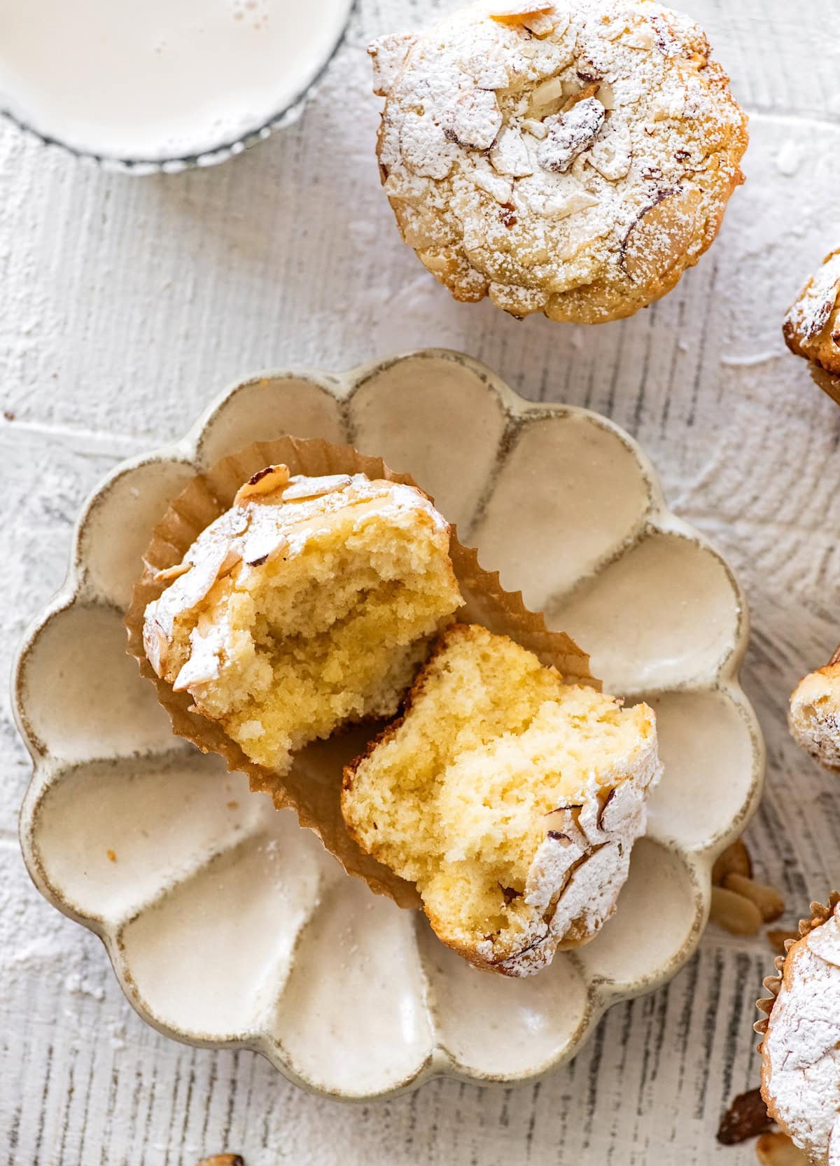 almond croissant muffin on plate cut in half with almond filling. 
