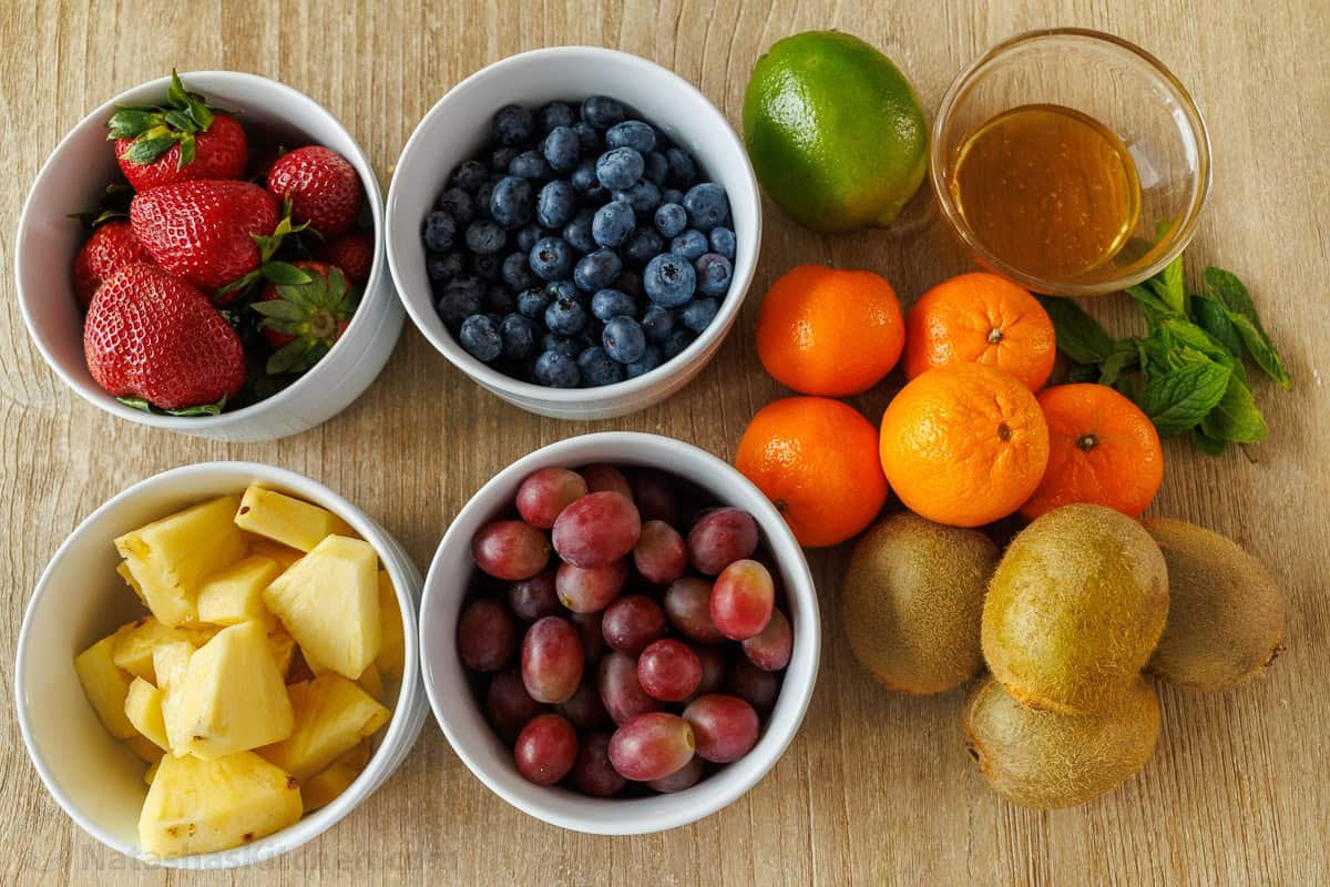 Classic Fruit Salad recipe features mixed fruit and a tasty honey-lime dressing. Bring this to your next potluck or gathering. Easy and fun! citrus and berries in separate bowls with honey lime dressing
