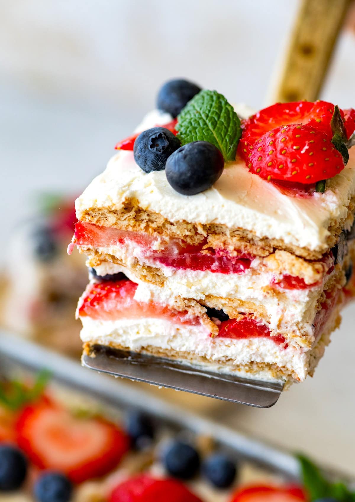 piece of berry icebox cake being lifted out of pan. 