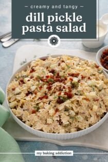 Serving bowl filled with dill pickle pasta salad, topped with crumbled bacon. Text overlay includes recipe name.