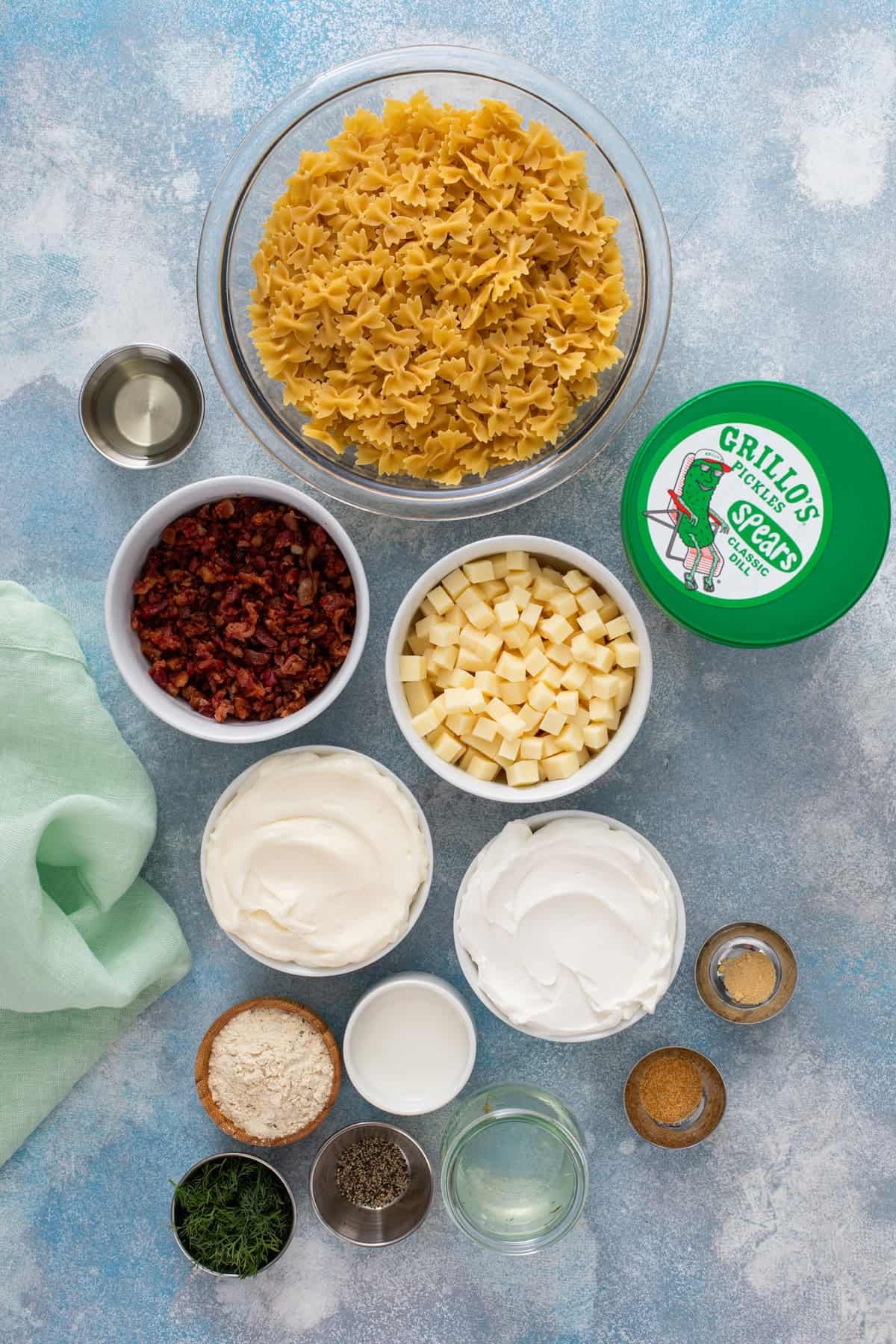 Ingredients for dill pickle pasta salad arranged on a countertop.
