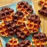 Liege waffles on a platter with one eaten on the side.