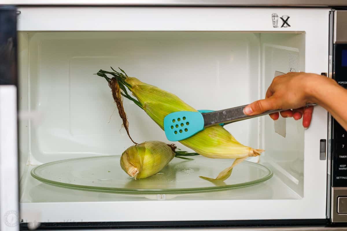 Microwave corn on the cob is the easiest way to serve corn in just minutes! No need to remove the husks. It's the perfect summer side dish. Removing whole ears from the microwave with tongs