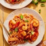 Tomato butter pasta on two plates with a fork in one.