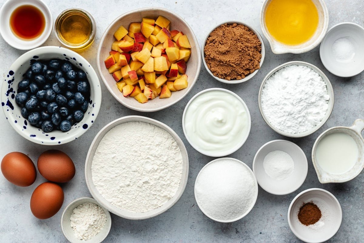 ingredients in bowls to make peach blueberry cake with streusel topping. 