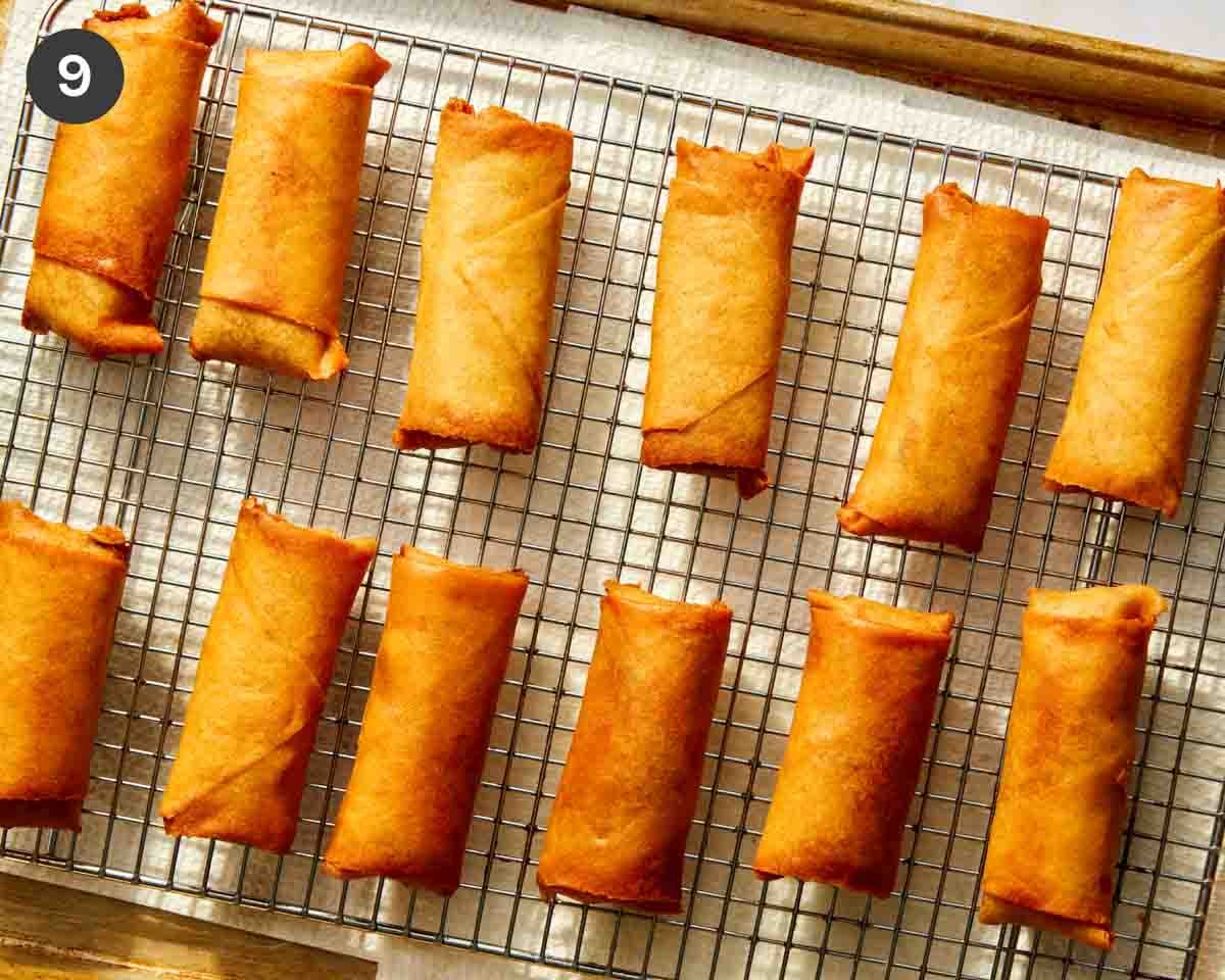 Fried spring rolls resting on a baking sheet.