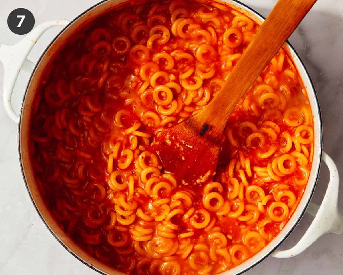 Cooked spaghetti os in a pot simmering.