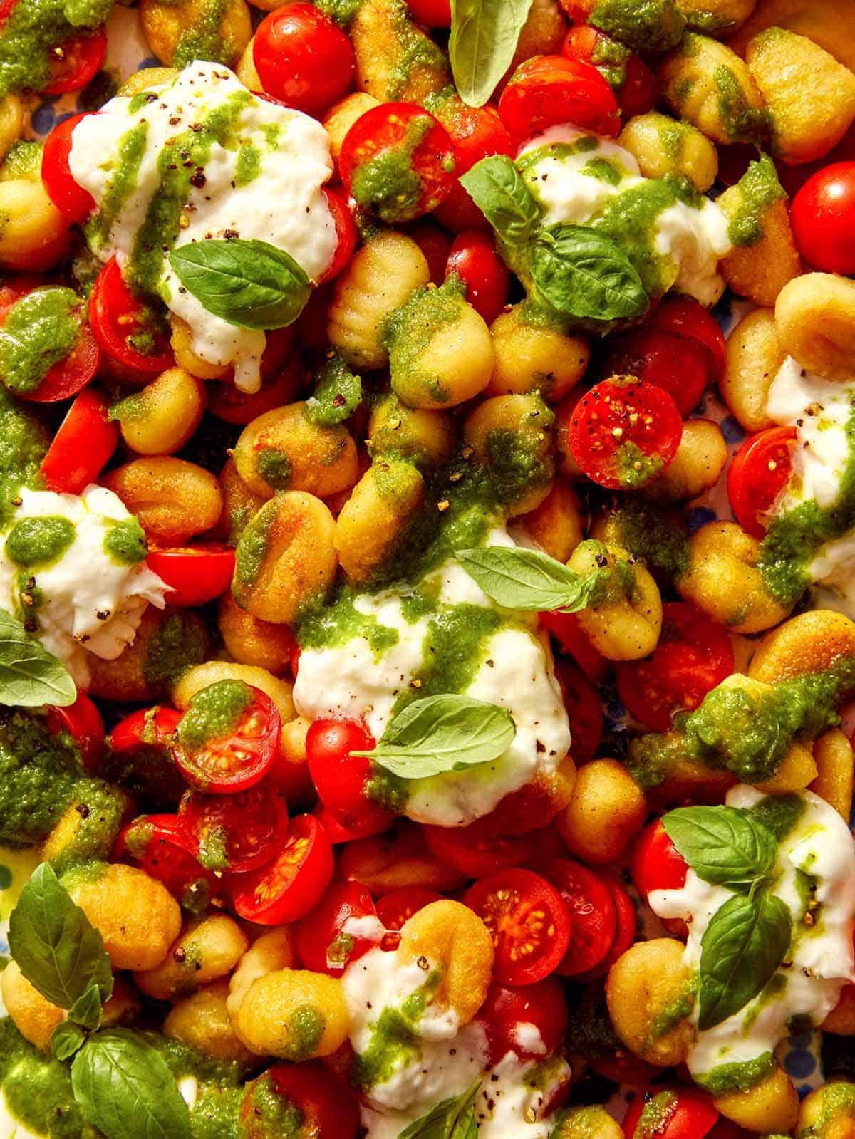Caprese pan fried gnocchi on a platter up close.