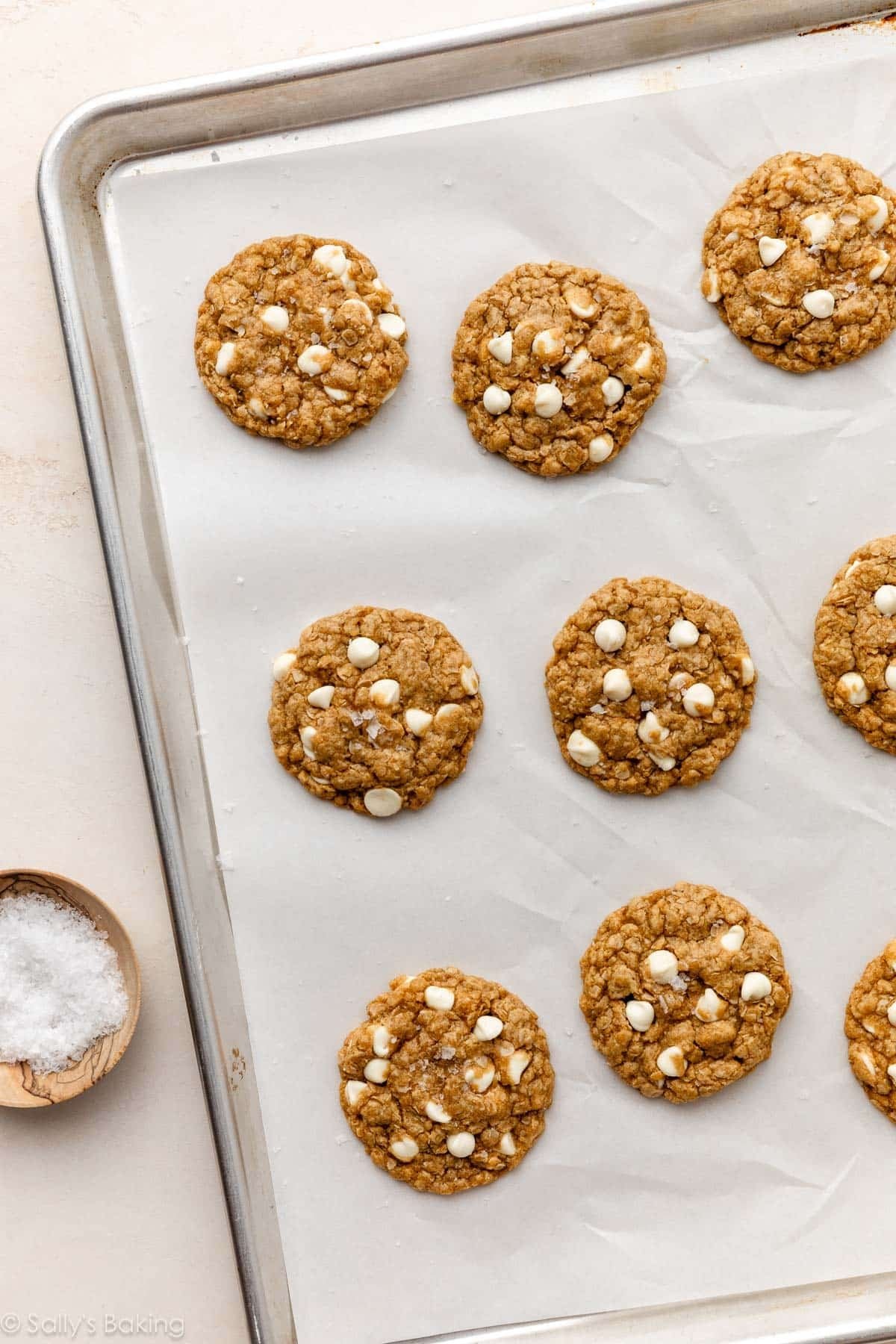 Baked Biscoff white chocolate oatmeal cookies on a lined baking sheet.