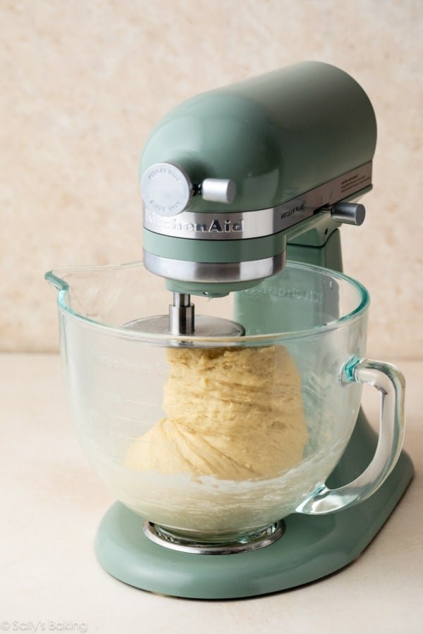 artisan plus stand mixer with dough in glass bowl.