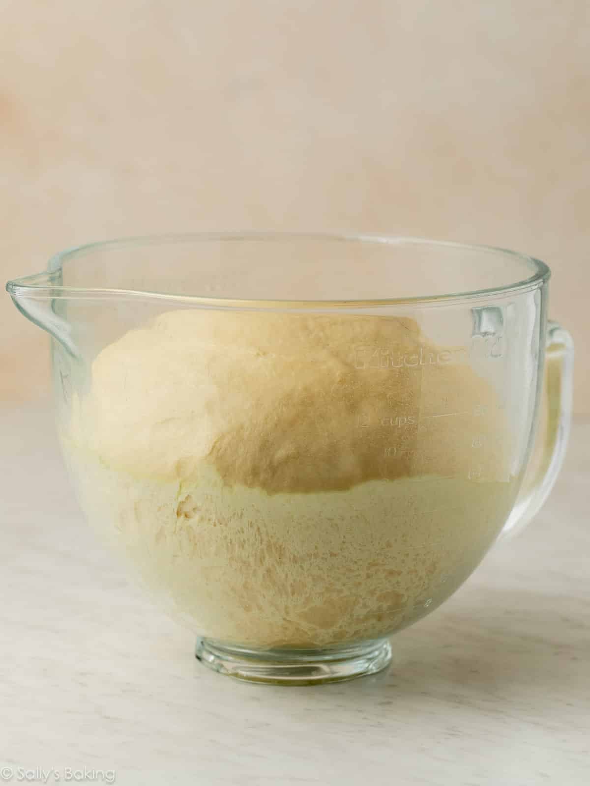 dough risen in glass bowl.