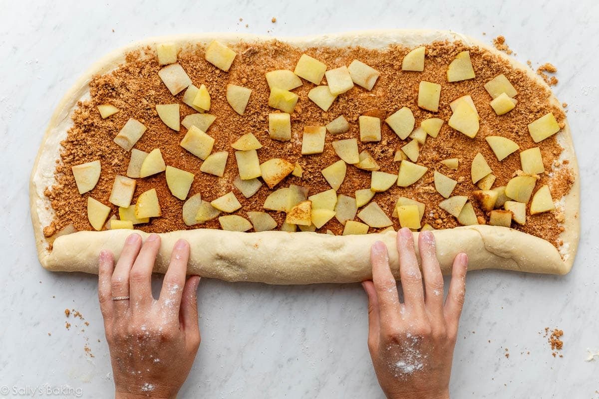 hands rolling up filled dough.
