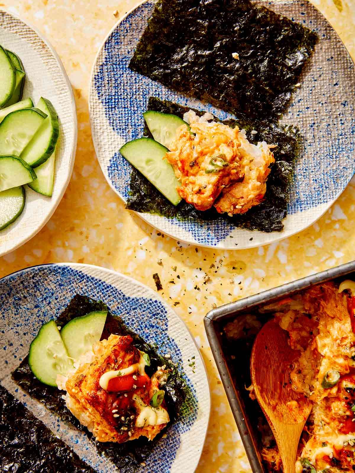 Sushi bake being served with cucumber slices.