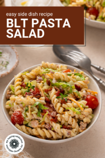Small bowl of BLT pasta salad on a countertop next to a spoon and fork. Text overlay includes recipe name.