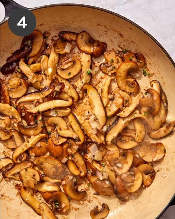 Mushrooms being cooked down in a skillet.