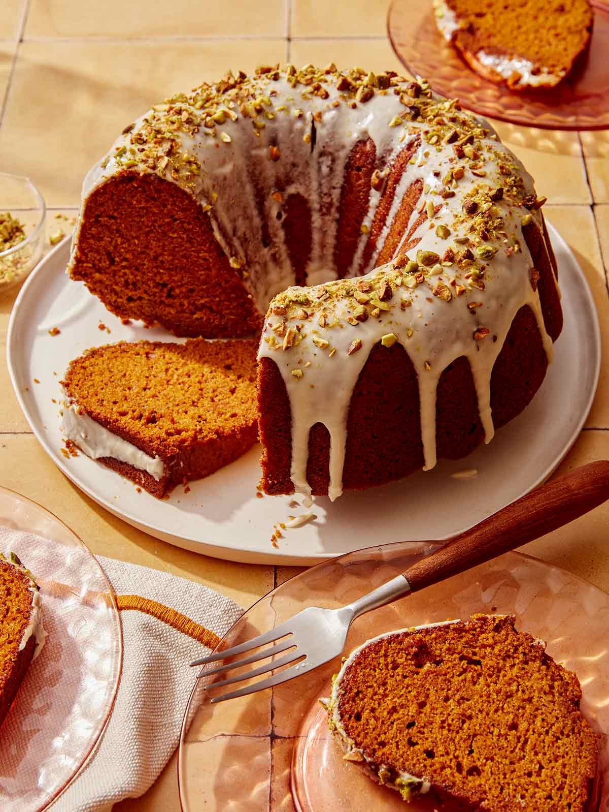 Pumpkin cake with a pistachio glazed cut with slices. 