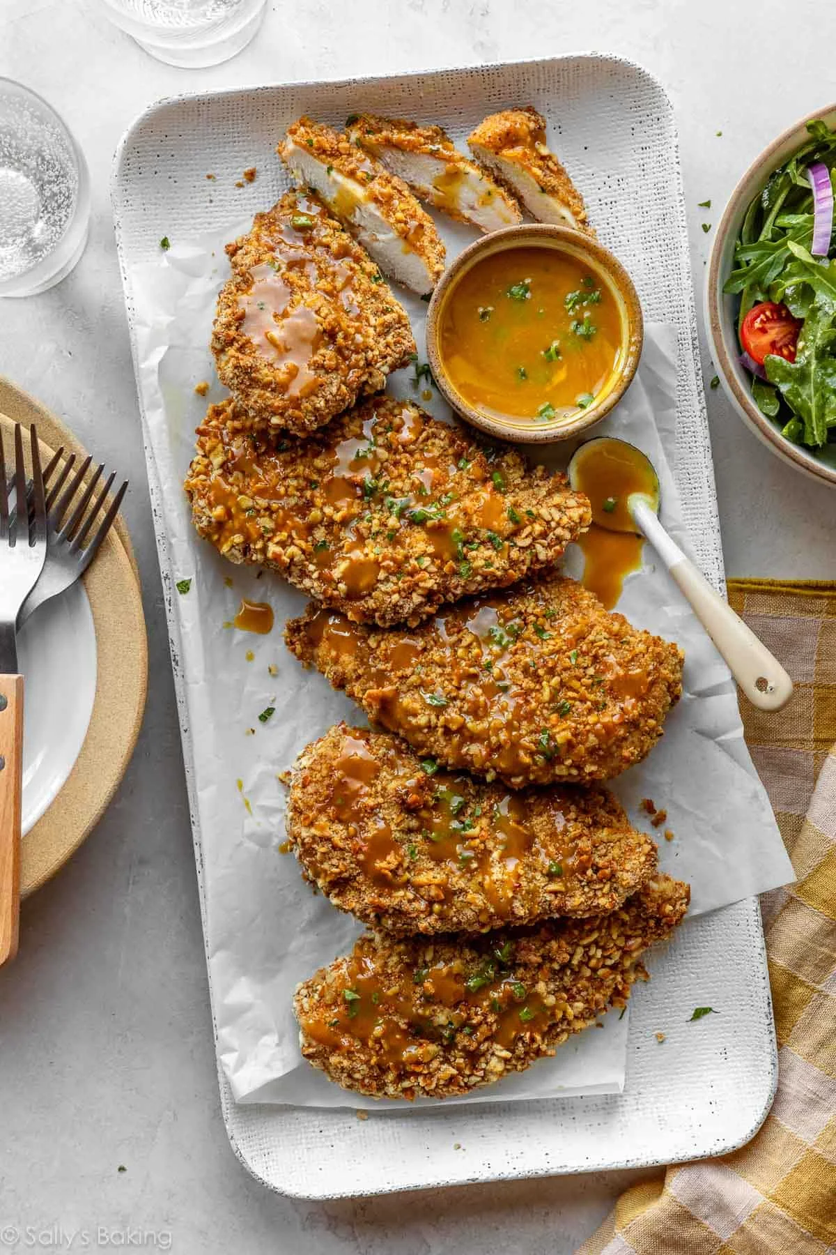 pretzel-crusted chicken on a platter with honey mustard dipping sauce.