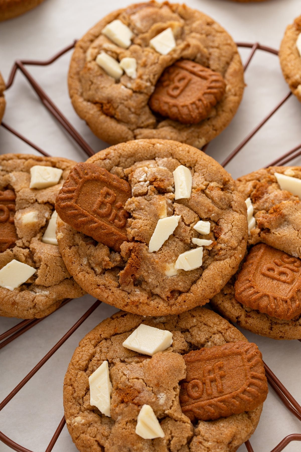 Close up of cookie butter cookies, showing the white chocolate chunks and biscoff cookie garnishing the cookies.